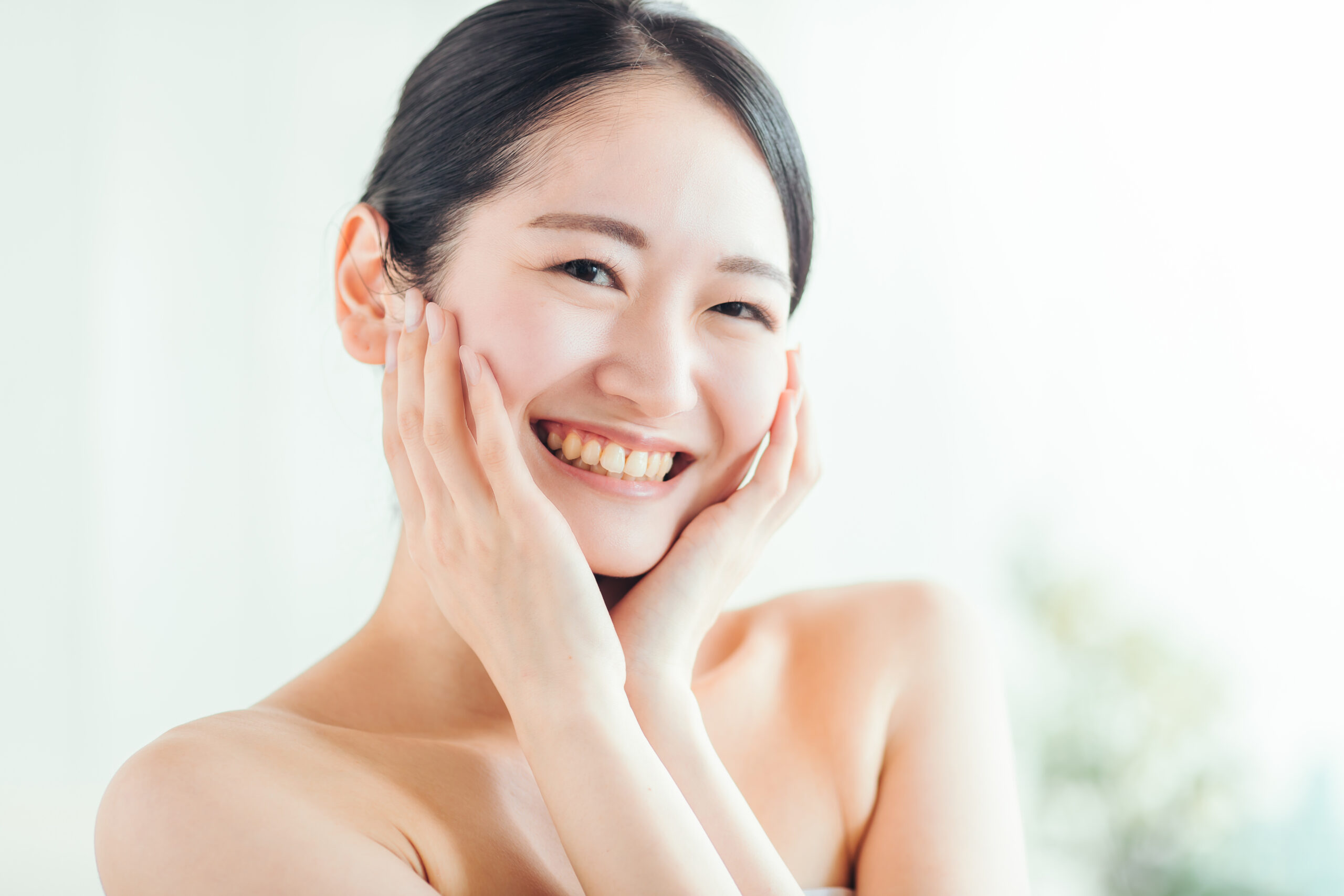 両手を頬にそっと添えて肌に意識を向ける女性