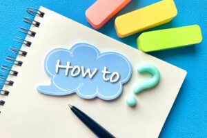 「How to」と書かれたノートとペン